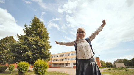 Happy eleven year old schoolgirl jumps in happy emotions.の写真素材