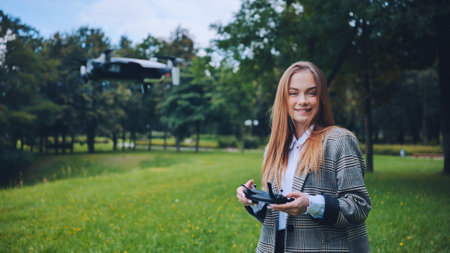 A cute girl controls a drone in the park.の写真素材