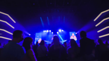 Audience enjoying live music concert with blue stage lights illuminating the venueの写真素材