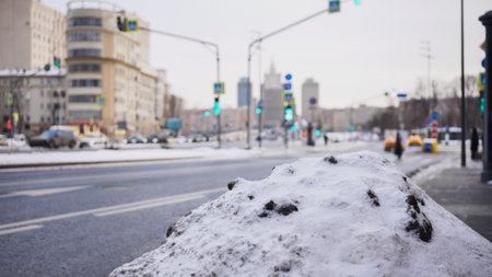 Snow pile by the roadside covering dirty frozen ground in Moscow winterの写真素材