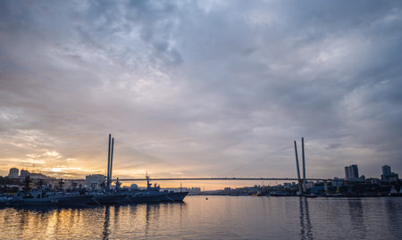 Russian navy warships are docked in the golden horn bay in vladivostok, russia, at sunset, with the...