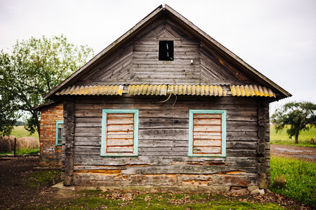 Old abandoned wooden house falling apart in countryside landscapeの写真素材