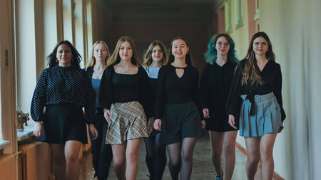 High school girls strolling through hallway, exuding style and camaraderie during school dayの写真素材