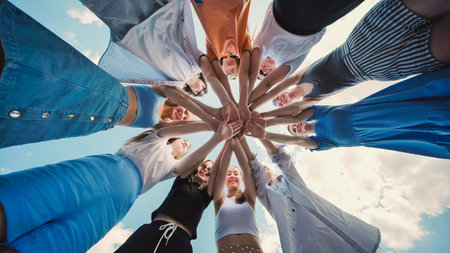 School friends joining hands in a circle, showcasing their unity, teamwork, and strong bond with cheerful attitudeの写真素材