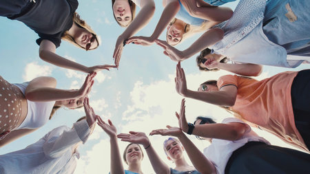 Group of school friends joining hands forming a star shape, symbolizing unity, teamwork, and...