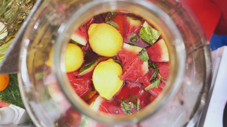 Refreshing watermelon and lemon detox water being prepared in glass jarの写真素材