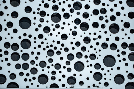 Perforated metal panel creating a contemporary abstract circle background