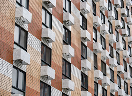 Modern residential building facade with many windows and external air conditioners