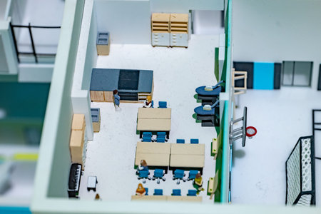 Architectural model displaying interior rooms with miniature people and furniture