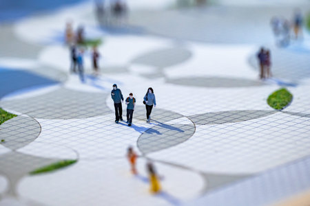 Miniature people walking on an architectural model of a public park layout