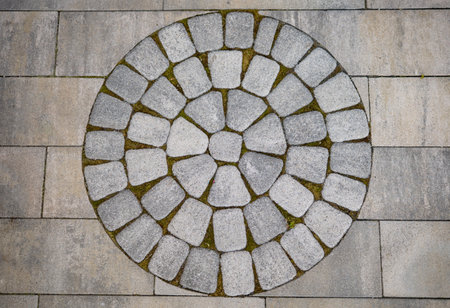 Cobblestone circle pattern forming a design on modern outdoor pavingの写真素材