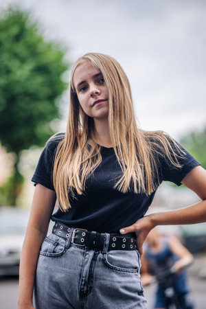 Blonde teen girl posing confidently with street style, expressing individuality outdoors