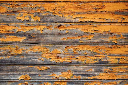 Old wooden planks showing peeling orange paint creating grunge background