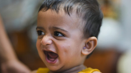 Happy little baby laughing with mouth open expressing pure joy and innocence