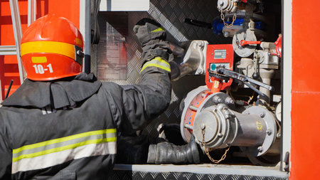 Firefighter connecting a hose to the fire engine pump system during an emergency response