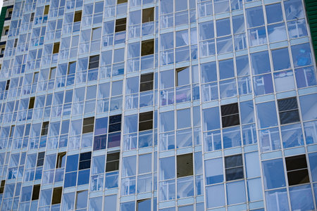 Modern glass building facade with apartments, reflecting bright urban architectureの写真素材