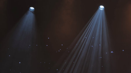 Two bright spotlights shining on a dark stage creating dramatic light beams with haze