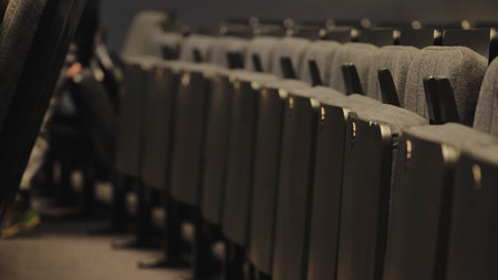 Diagonal row of empty seats in a dark theater auditoriumの写真素材