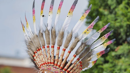 Traditional native American headdress showing vibrant feathers and intricate beadwork details