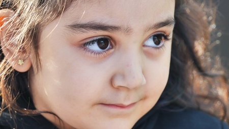 Young girl with brown eyes looking away showing curiosity and innocence