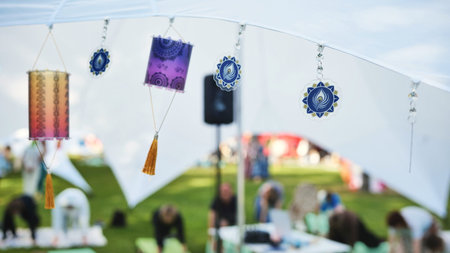 Indian cultural lanterns and peacock symbols decorating a tent at an outdoor festival
