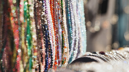 Colorful sparkling beads reflecting light and hanging in an Indian market stall