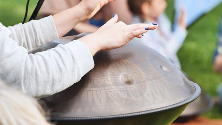 Musician playing a handpan with engraved patterns at India Day in Moscow