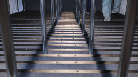 People ascending carpeted stairs at a public exhibition with a green balloon