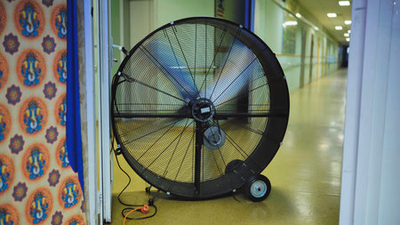 Giant industrial fan ventilating a long hallway during Ganesha festival in India