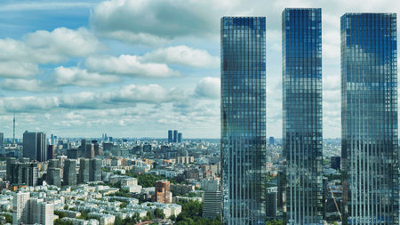 Three skyscrapers towering over Moscow cityscape under cloudy sky