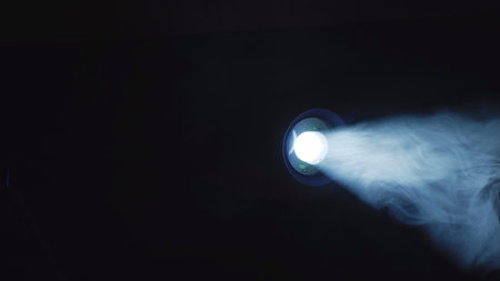 Projector light beam projecting through smoke in a dark room