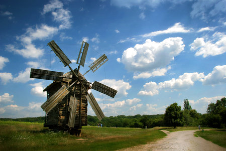 Windmill with the blue clouds and green grass