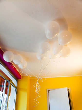 White ballons in yellow and fuchsia room の写真素材