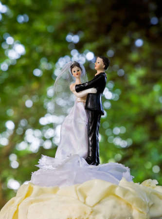 Little dolls (brige and groom) on wedding cake.の写真素材