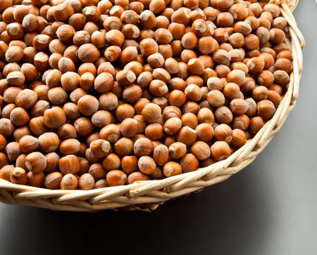 Hazelnuts in a basket on gray backgroundの写真素材