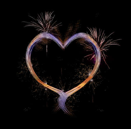 Heart with fireworks against a black sky.の写真素材