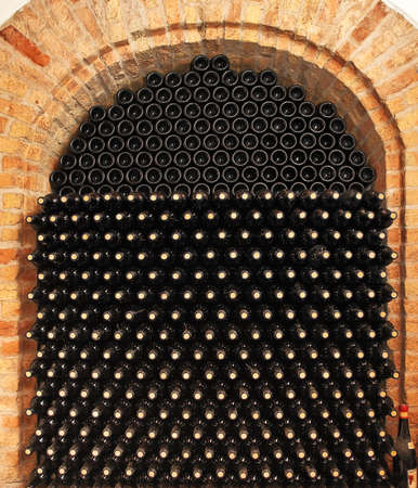 Bottles of red wine in cellar or wine shop.の写真素材