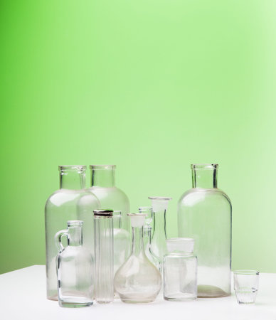 Empty glass bottles on green with space for text の写真素材