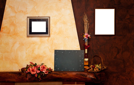 Two empty frames, a blackboard, a bottle,  on yellow and brown wallの写真素材