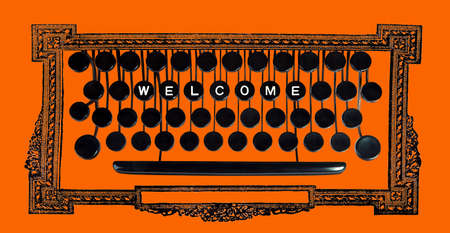 Welcom spelled on a vintage keyboard on orangeの写真素材