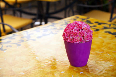 Pink roses on yellow modern tableの写真素材