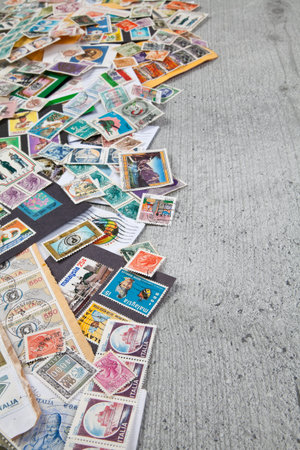 Old postage stamps from different countries on wooden table
