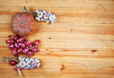 Pumpkin, onions and garlic on wooden backgroundの写真素材