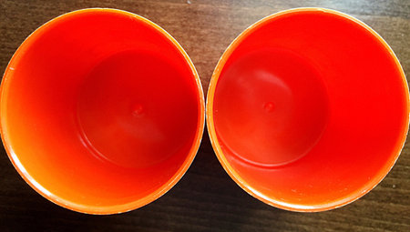 Two orange plastic glasses