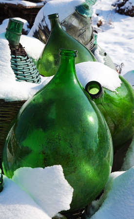 Old demijohns in the snowsの写真素材