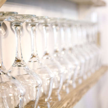 Empty wine glasses in row on wooden bar. Selective focus.の写真素材