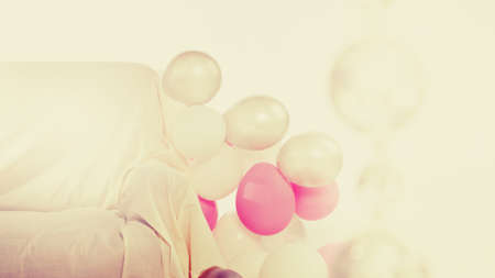 Interior with white and pink balloons and sofa (background for party, with space for your logo or text)の写真素材