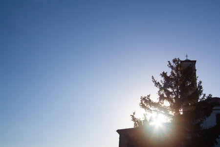 Silhouette of a Christian church and a tree at sunset. With space for logo or text