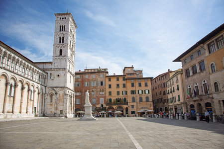 Lucca, Tuscany, Italy. Piazza San Michele, on left the Church of San Michele in Foro, in center of the square the staute of Francesco Burlamacchi. Around medioeval building and shopsのeditorial素材