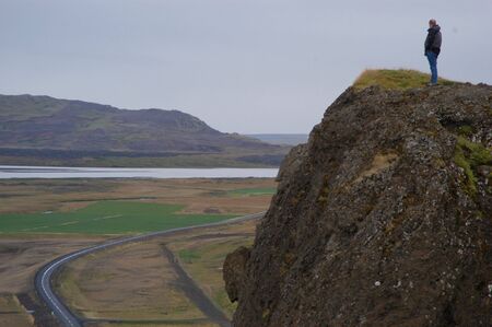 Man on cliff overlooking a roadの写真素材